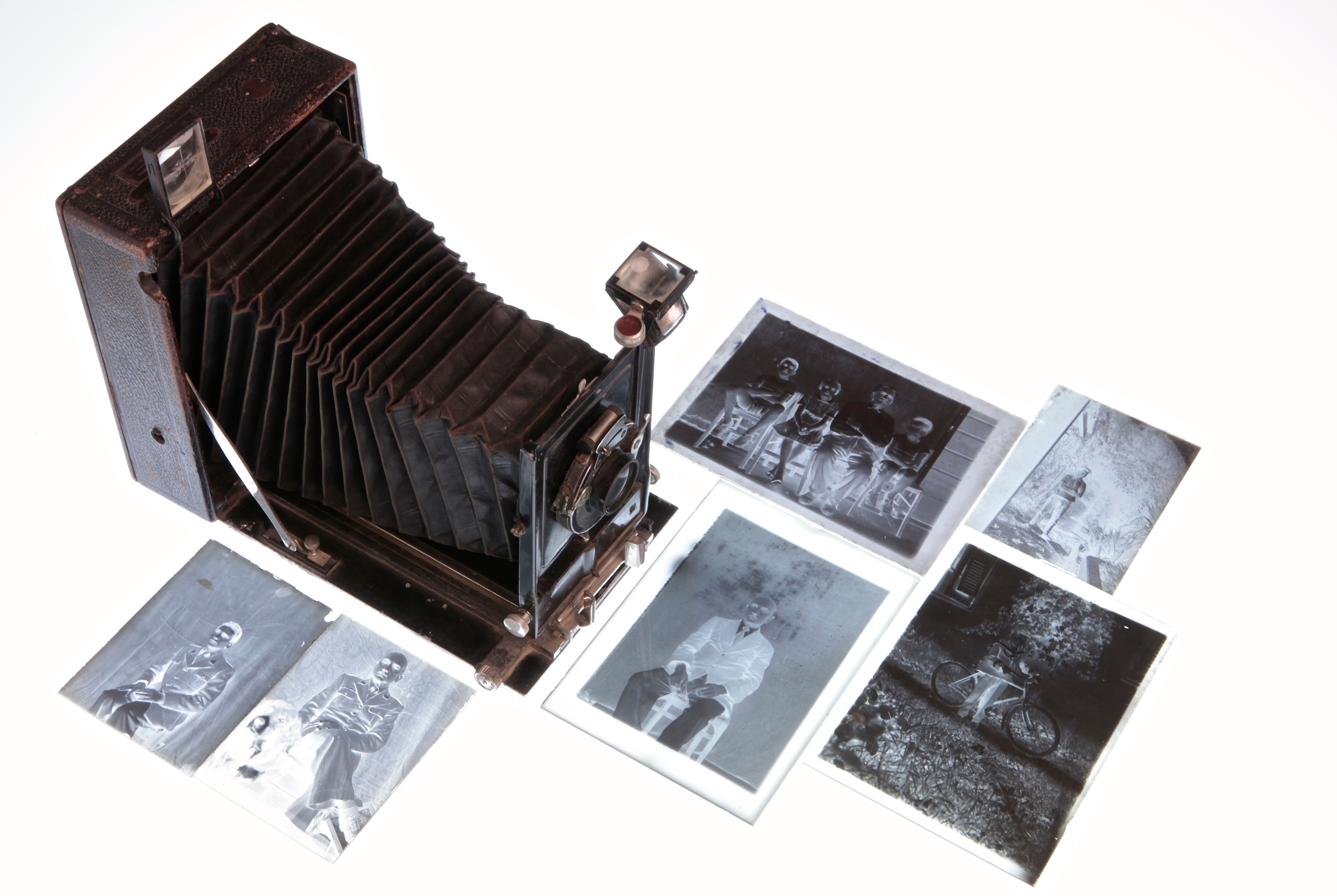 Des négatifs photos et un tirage sur papier à coté d'un appareil photo moyen format à souflet.
